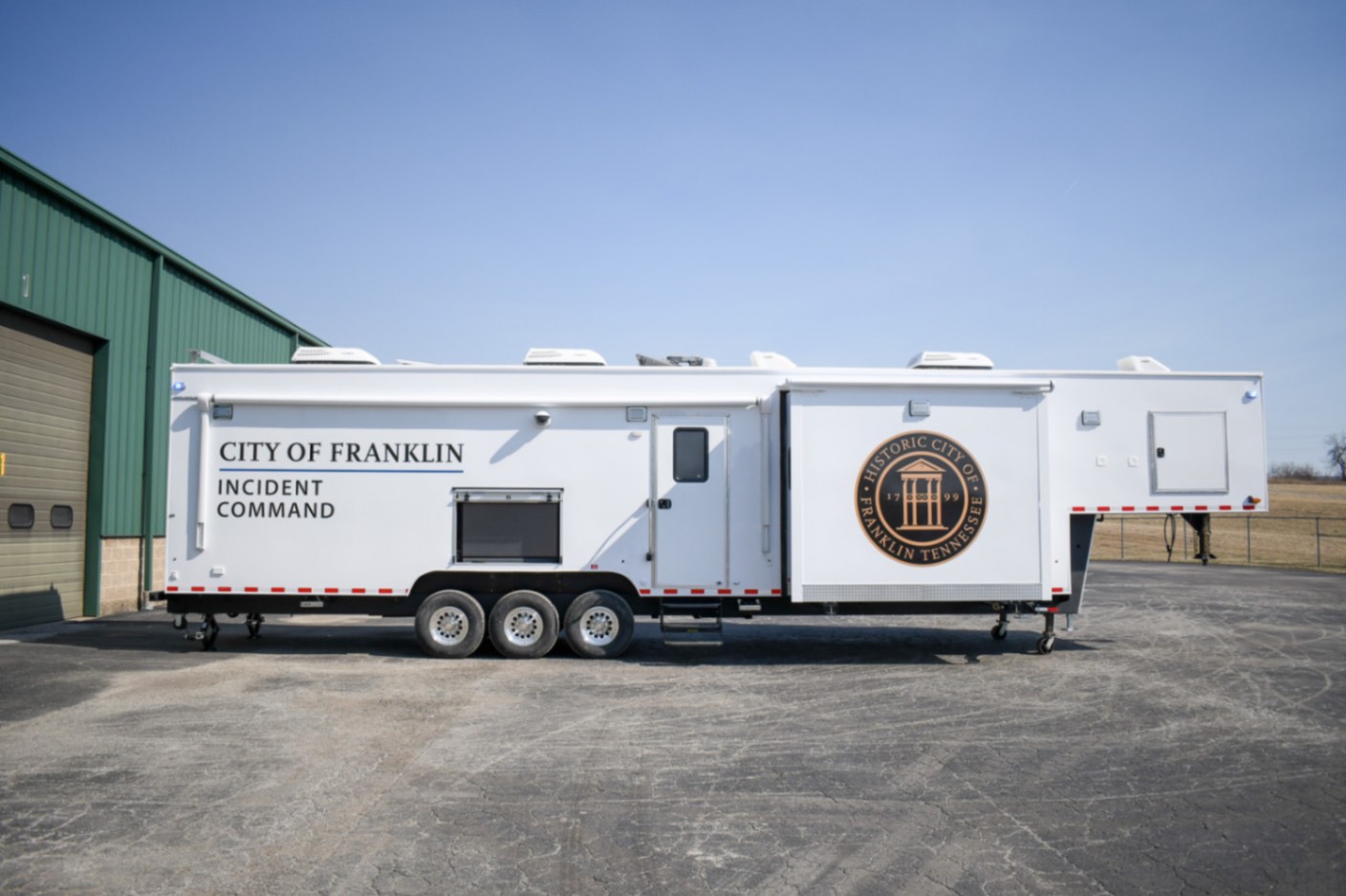 A side view of the Command 42-7WS FW 2SO made for Franklin, TN. The slideouts are deployed.