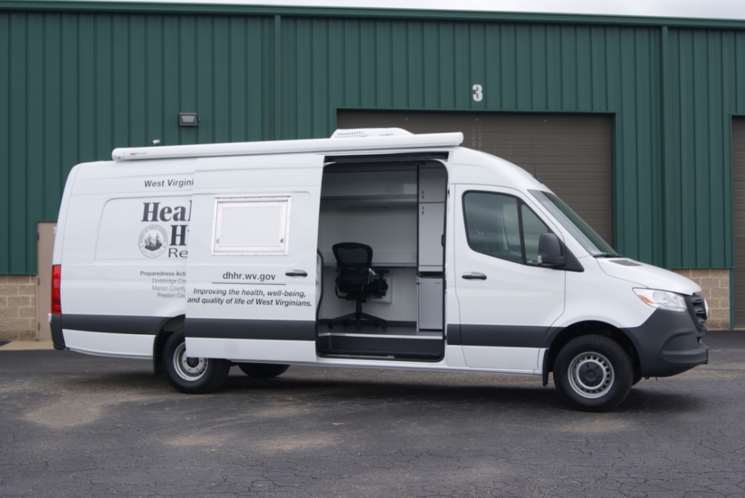 An exterior view of an Immunization Sprinter made for the WV DoH. The side door is open.