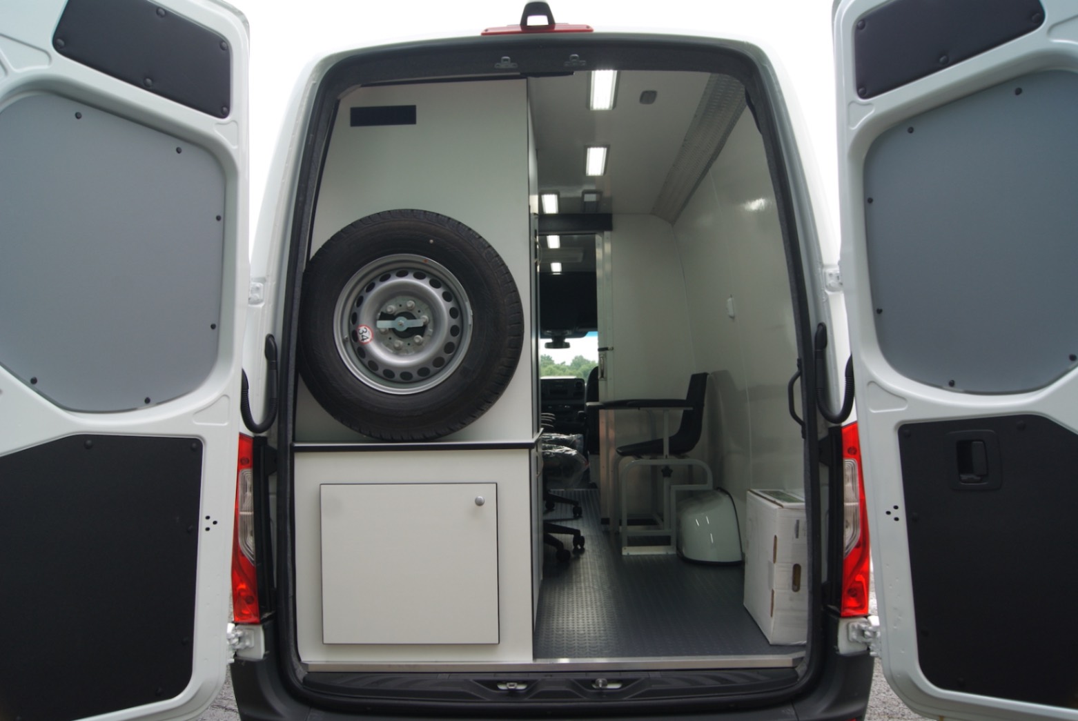 An exterior view of an Immunization Sprinter made for the WV DoH. The rear doors are open.