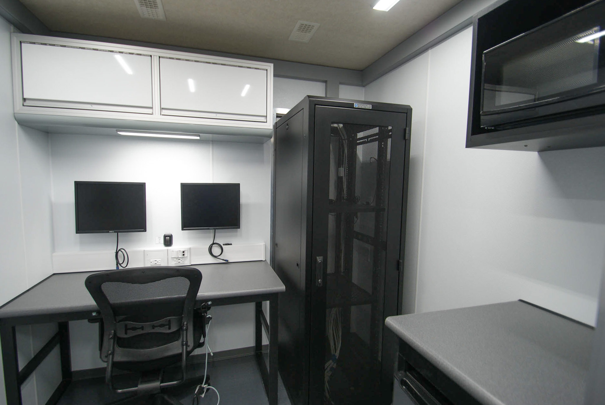 A view of a workstation, kitchenette, and electronics rack cabinet inside the unit for Delhi, NY.