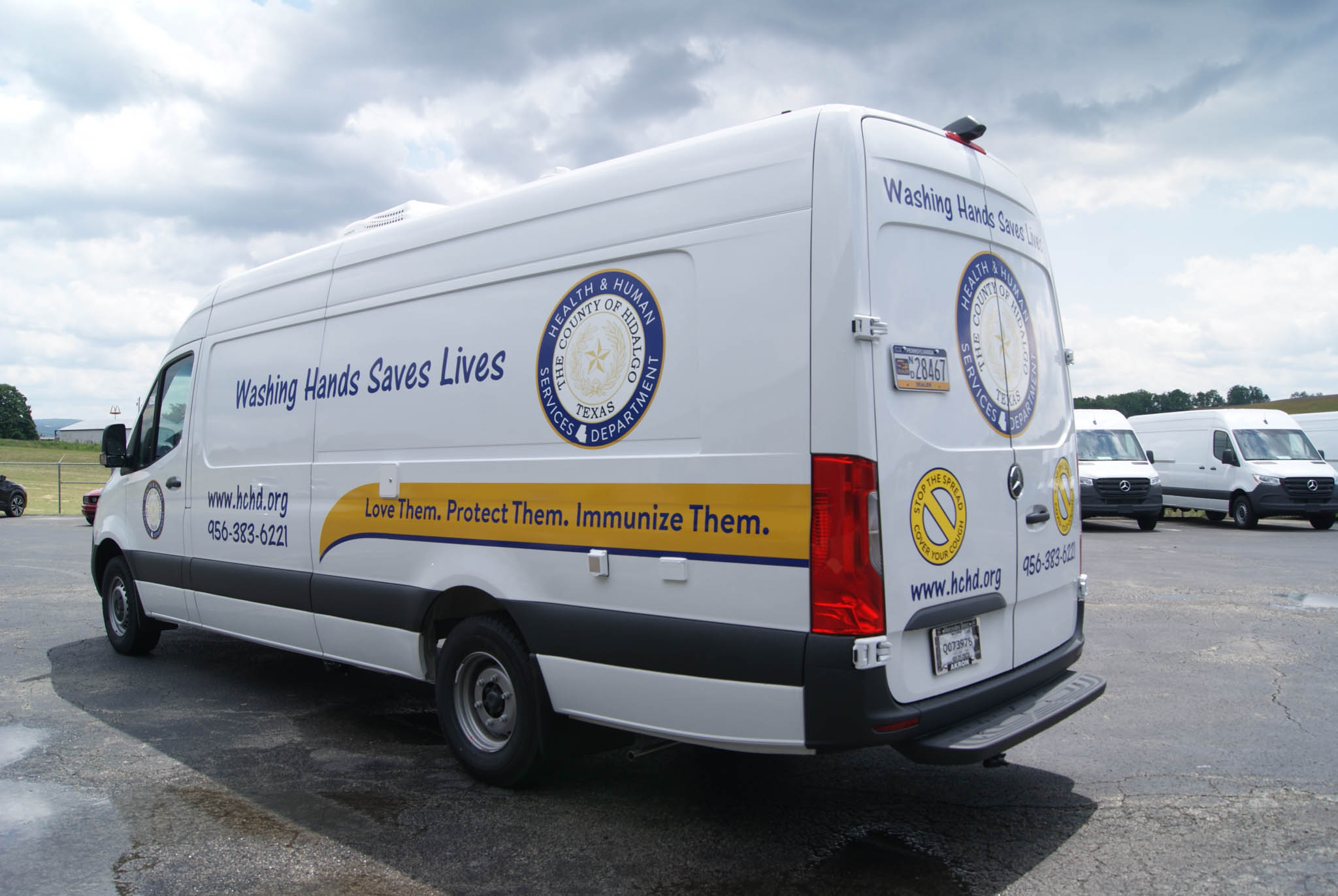 An angled view of the Mobile Medical Exam sprinter's rear decals.