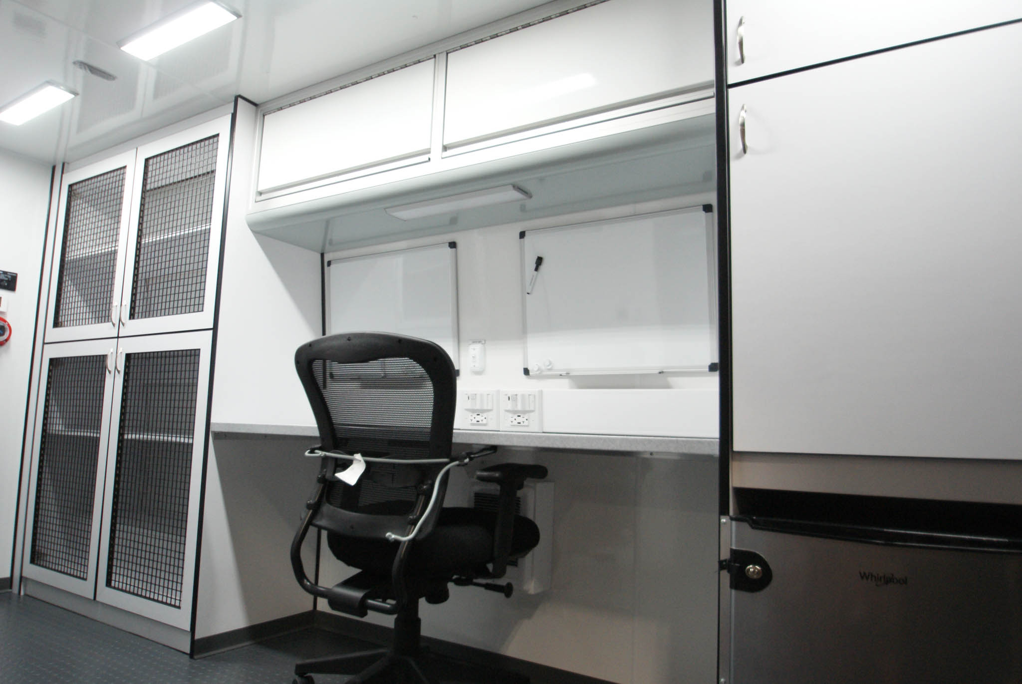 A view of the workspace, refrigerator, and cabinets inside the unit made for Escondido, CA.