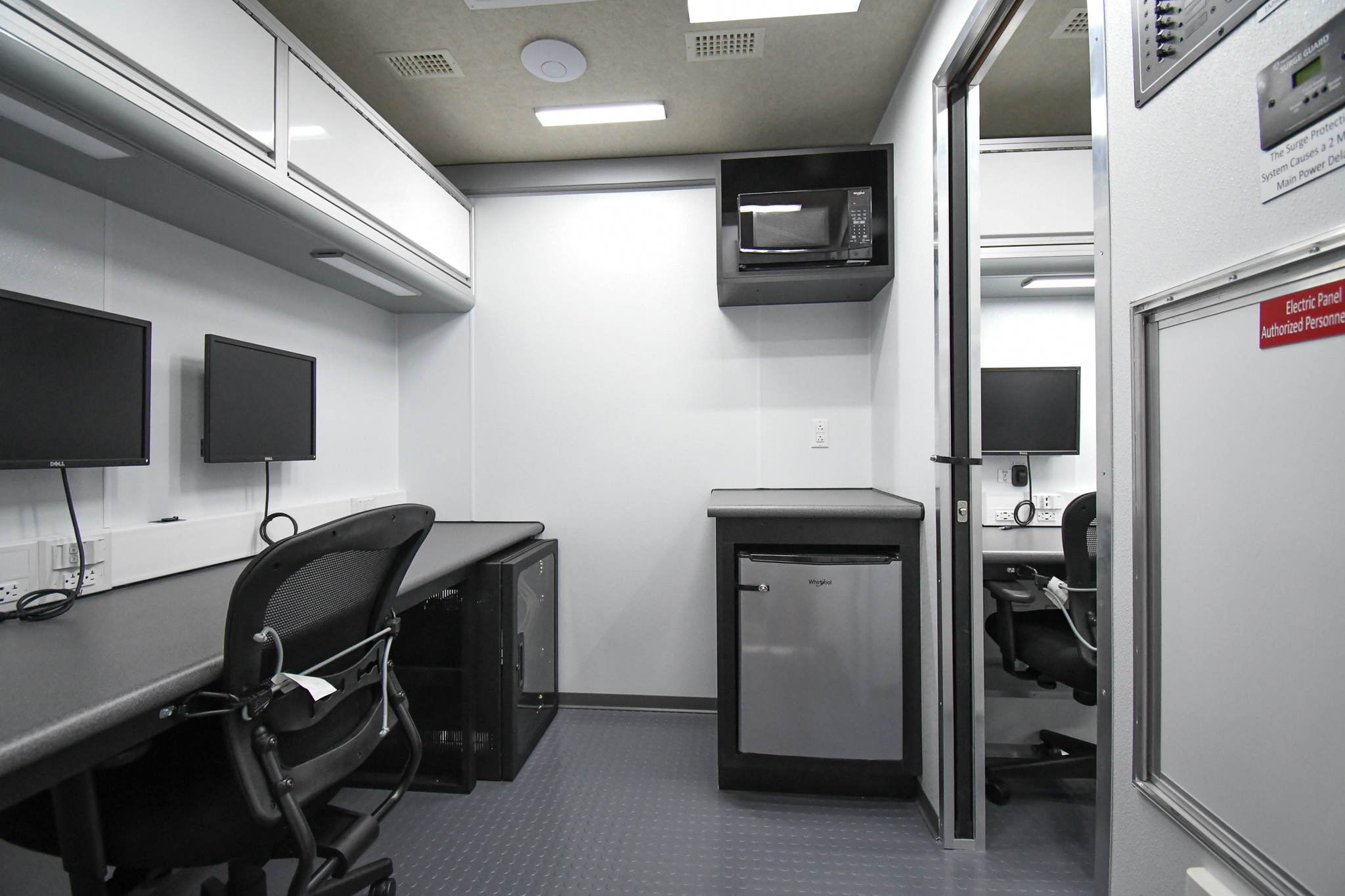 A view of a workstation, kitchenette, and electronic rack floor cabinet inside the unit for Caribou, ME.