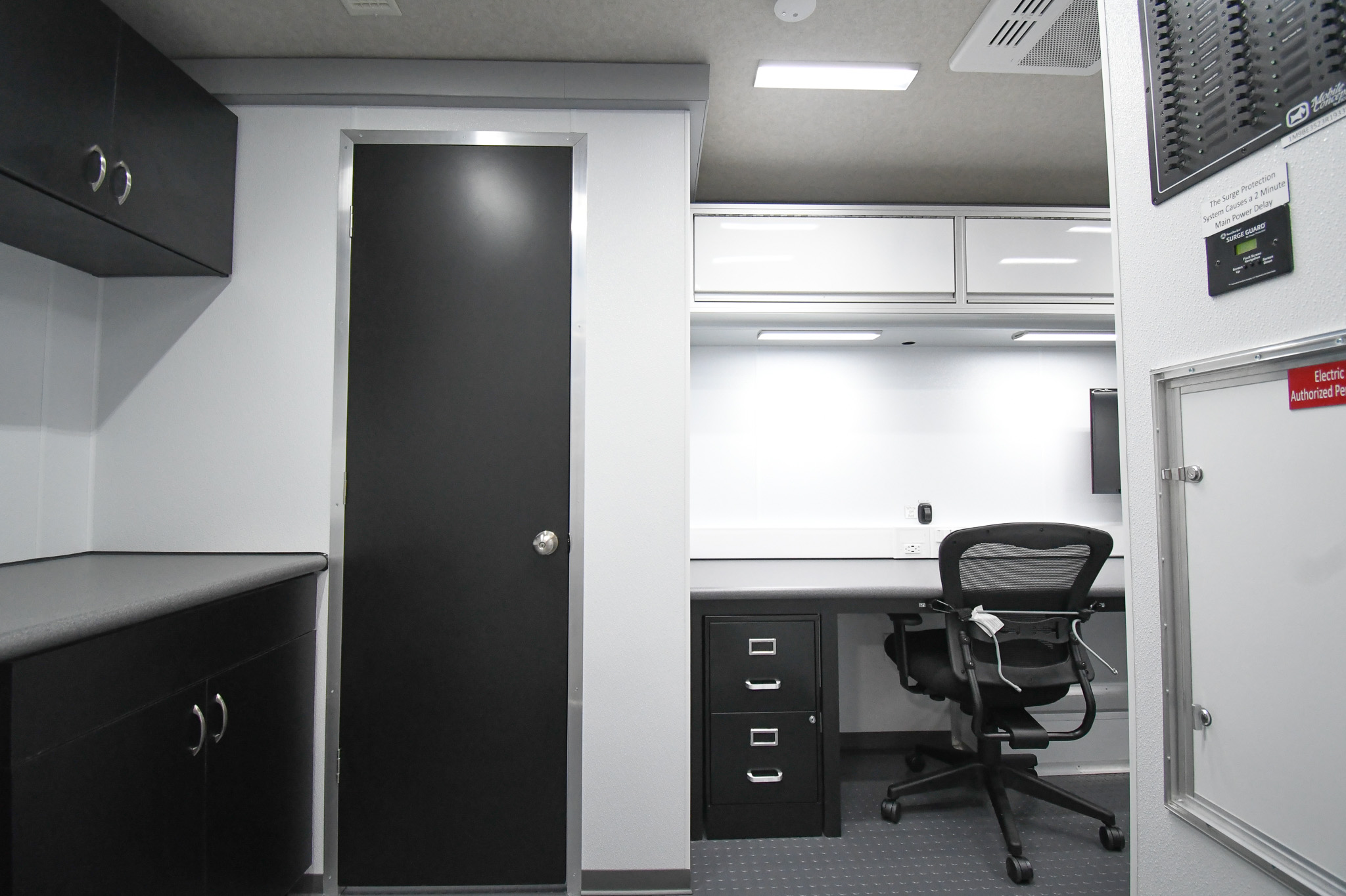 A view of the kitchenette, a workstation, and the door to the storage closet inside the unit for Richland County, MT.