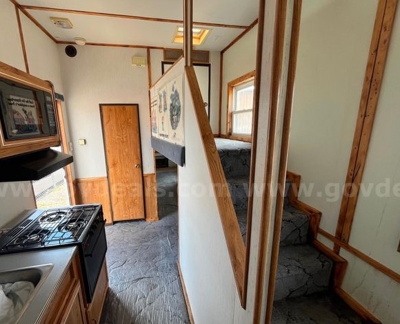 The kitchen stage and stairway to the second floor inside the HD-2800 Smoke House Trailer.