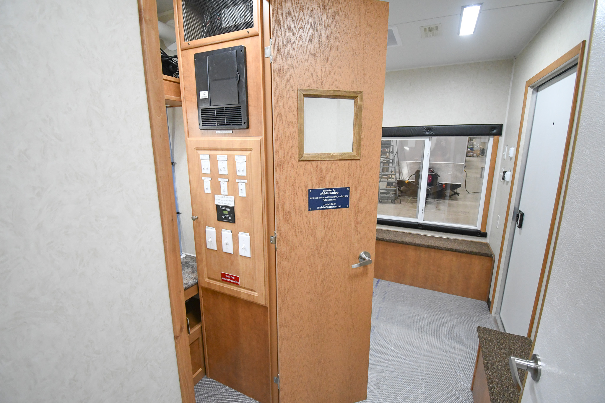 A front-to-back view, starting from the kitchen doorway, inside the unit for Lancaster, OH. The control room door is open.