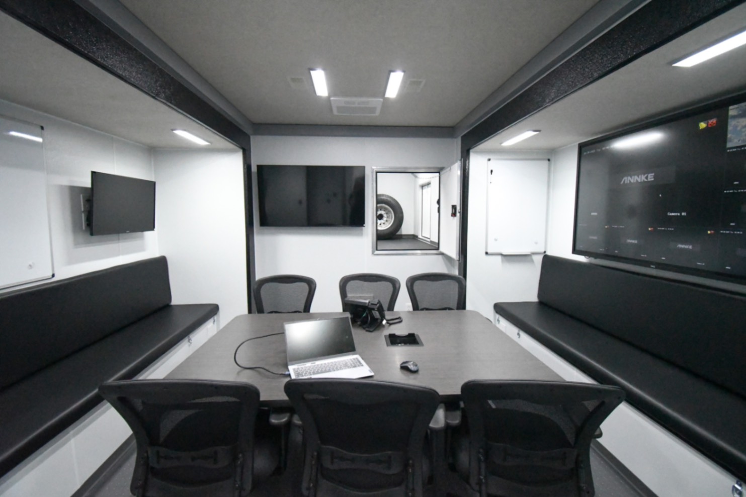 The conference room inside the Command 42-5WS FW 2SO made for Sweetwater, FL. The door to the fifth wheel storage space is open.