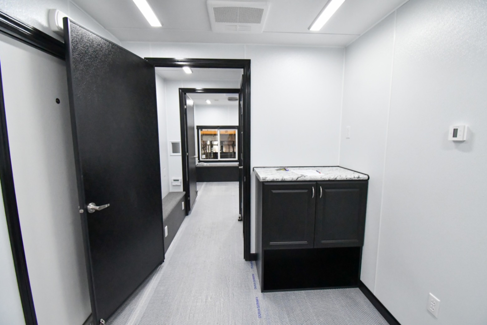 A front-to-back view inside the 31Bleacher Mod made for Burien, WA. The door to the hallway is open.